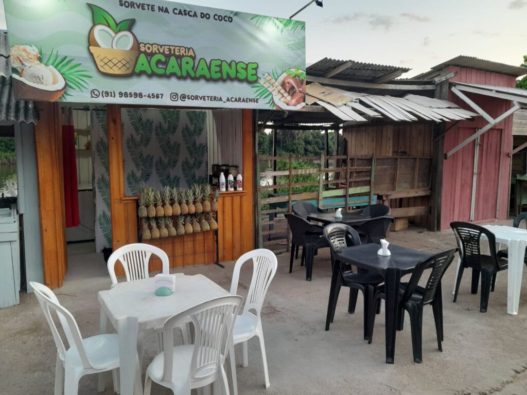 Fachada da Sorveteria Acaraense na orla do Acará, com os abacaxis pendurados e as mesas de frente para o rio